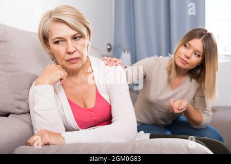 daughter comforts a sad mother Stock Photo