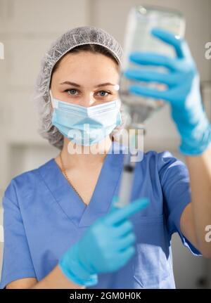 Nurse fills syringe with injection solution Stock Photo