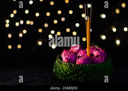 Selective focus on pink lotus flower decorates on banana leaves Krathong with bokeh lights background for Thailand full moon or Loy krathong festival. Stock Photo