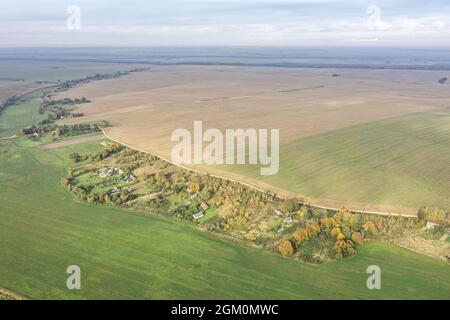 countryside view with village among cultivated fields at foggy morning. panoramic drone photo. Stock Photo