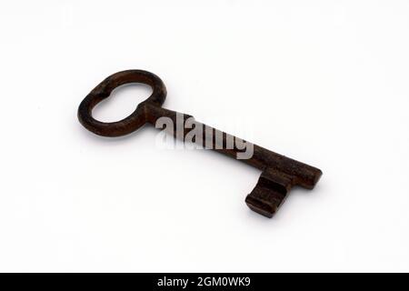 Old iron rusty key on white background. Selective focus. Close up. Stock Photo