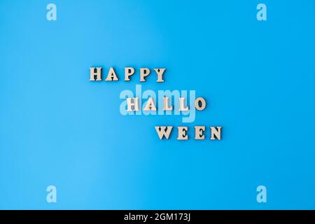 Happy halloween text made of wooden letters on blue background. Greeting card Stock Photo