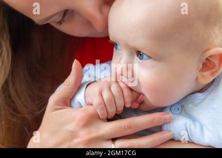 Little baby holding mother's finger in mouth. Stock Photo