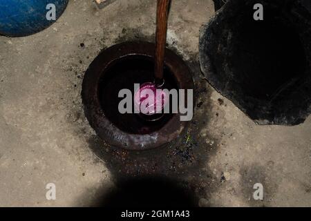 Homemade wine being taken out of a traditional a clay jug called Kvevri buried on the ground in Kakheti, Georgia. Stock Photo