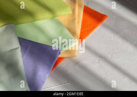 Stack of colorful cotton fabric against grey background, slow fashion and home sewing concept Stock Photo
