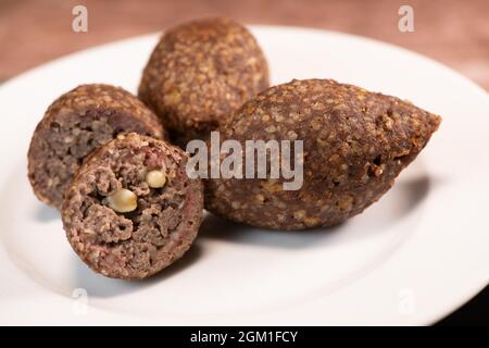 Traditional kebbe and pita bread on big round plate in lebanese restaurant Stock Photo