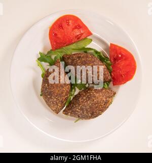 Traditional kebbe and pita bread on big round plate in lebanese restaurant Stock Photo