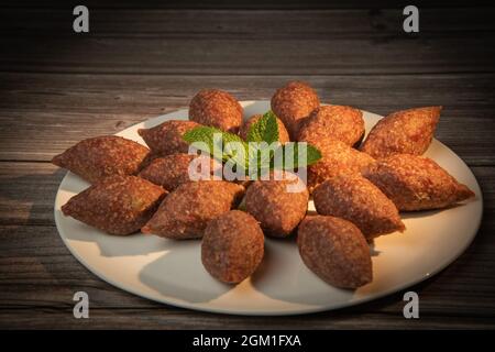 Traditional kebbe and pita bread on big round plate in lebanese restaurant Stock Photo