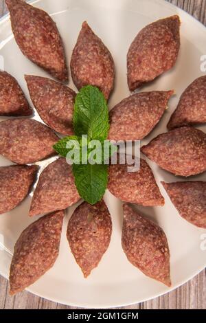 Traditional kebbe and pita bread on big round plate in lebanese restaurant Stock Photo