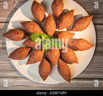 Traditional kebbe and pita bread on big round plate in lebanese restaurant Stock Photo