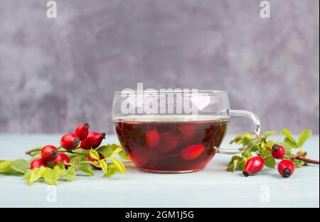 Hip rose tea with fresh fruits and leaves, hot drink in autumn and winter Stock Photo