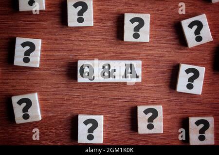 Question and answer concept. Top view of wooden cube with question mark symbol and text Q and A. Stock Photo