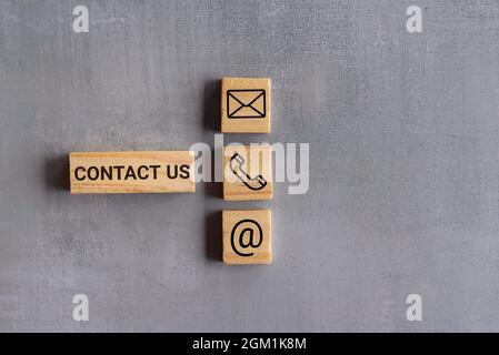 Business concept. Contact us text and icon on wooden cubes. Copy space for text. Stock Photo