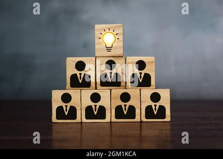 Teamwork, brainstorming and creative concept. Wooden cube block with light bulb and human symbols Stock Photo