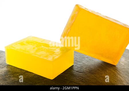 Still life of artisan and organic lemon and orange soaps with white background. Stock Photo
