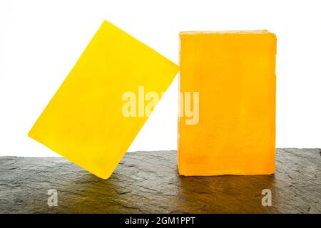 Still life with front view of artisan and organic lemon and orange soaps with white background. Stock Photo
