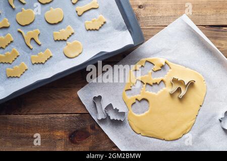 Cookies in various shapes for Halloween on a baking sheet. Cookies cut before baking. Copy space. Stock Photo