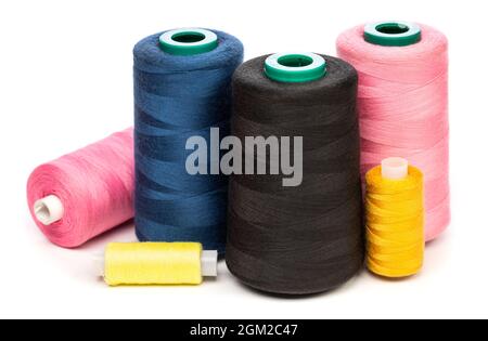 Synthetic or cotton thread spools of various colors isolated on white background. Spool of yarn using for weaving in textile manufacturing Stock Photo