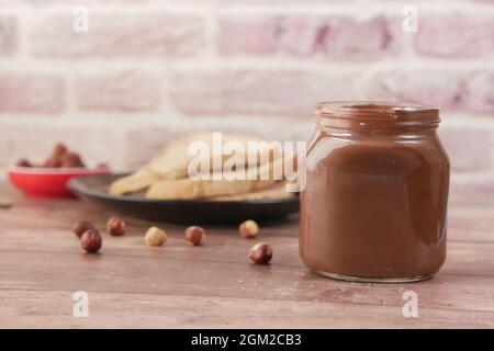 Chocolate Hazelnut in a container and bread on table  Stock Photo