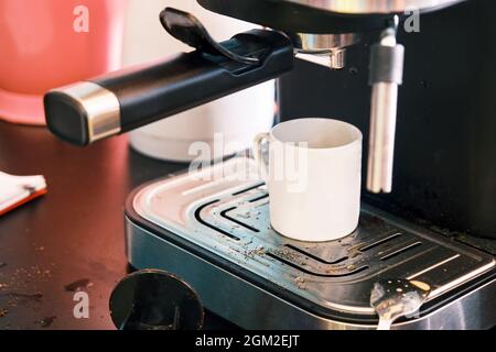 White espresso cup on espresso machine with messy and dirty bar counter. Stock Photo