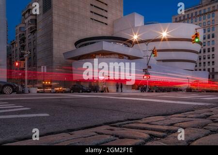 Guggenheim Museum NYC Light Streaks - View during twilight of the Solomon R. Guggenheim Museum and light trails on 89th Street and Fifth Avenue on the Stock Photo