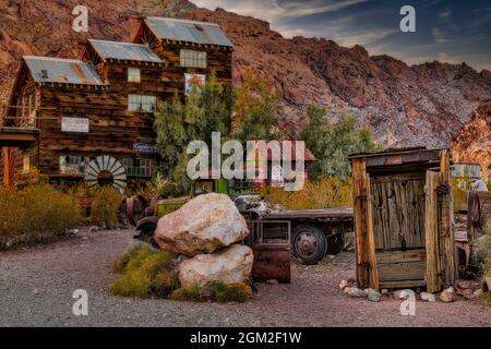 Ghosttown  - A ghosttown's view into the past. Vintage signs, rusty trucks and structures abound including a wooden outhouse.   A Gasoline station pum Stock Photo