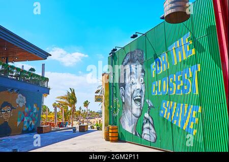 DUBAI, UAE - MARCH 4, 2020: The vintage style advertising murals on the metal walls of modern stores of La Mer Beachside shopping and dining district, Stock Photo