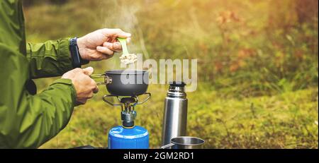 preparing food outdoors on gas burner. camping cooking equipment. copy space Stock Photo