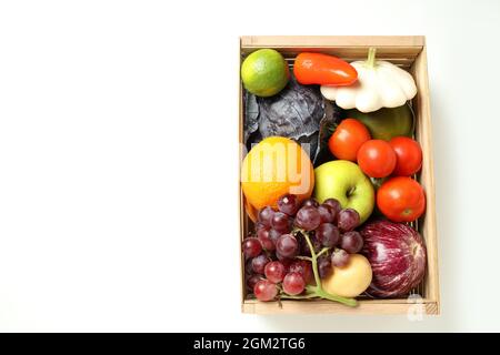 Wooden box with vegetables and fruits on white background Stock Photo