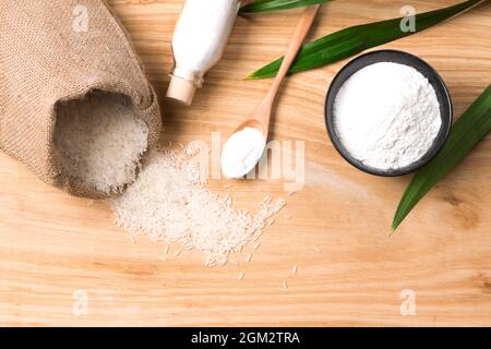 rice in hemp sack bag and white rice flour in wooden bowl Stock Photo