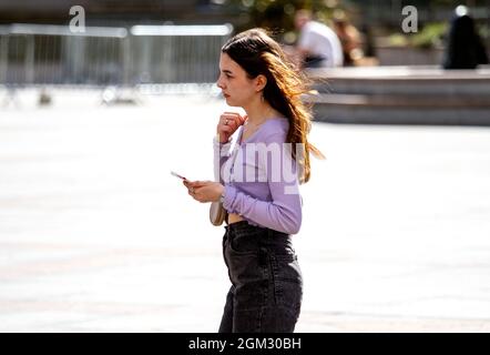 Dundee, Tayside, Scotland, UK. 16th Sep, 2021. UK weather: Warm mid September sunshine across North East Scotland with temperatures reaching 19°C. A young woman spending the day out enjoying the glorious warm sunny weather whilst talking on her mobile phone in Dundee city centre. Credit: Dundee Photographics/17�Թ����� Live News Stock Photo