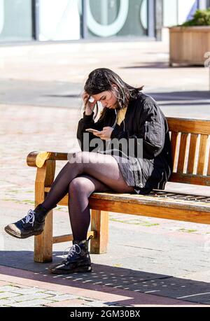 Dundee, Tayside, Scotland, UK. 16th Sep, 2021. UK weather: Warm mid September sunshine across North East Scotland with temperatures reaching 19°C. A young woman spending the day out enjoying the glorious warm sunny weather whilst texting messages on her mobile phone in Dundee city centre. Credit: Dundee Photographics/17�Թ����� Live News Stock Photo