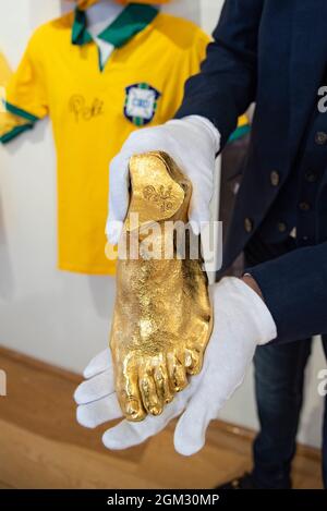 London, UK. 16th Sep, 2021. Martin Nolan, Executive director of Julian's Auction, holds an 18 karat gold cast bronze sculpture replica of footballer Pele's foot at the Mall gallery in London, UK on September 16, 2021. All monies raised go to The Pele Foundation Covid- 19 recovery fund in Brasil. ( Photo by Claire Doherty/Sipa USA) Credit: Sipa USA/Alamy Live News Stock Photo