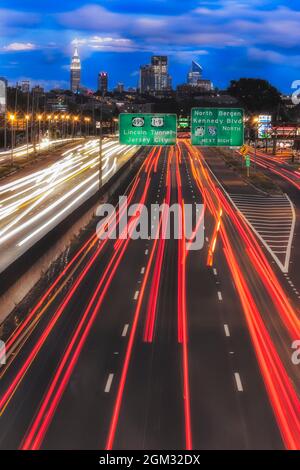 Path To And From NYC II - Vehicular light trails from route 3 in New Jersey lead to a view of the New York City skyline.   Showcased is the iconic lan Stock Photo