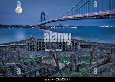 Verrazano Narrows Bridge Full Moon - View to Fort Wadsworth, the Verrazano Narrows Bridge, the New York Harbor under a full moon during the blue hour Stock Photo