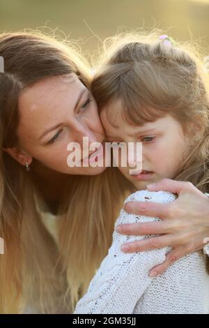 Mother comforts her crying resentful daughter while the walk. Portrait. Stock Photo