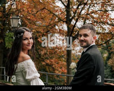 Portrait of beautiful young bride and groom with fall trees in background. Stock Photo