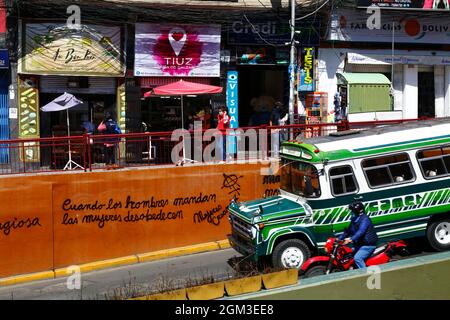 Vintage micro bus driving past feminist graffiti 