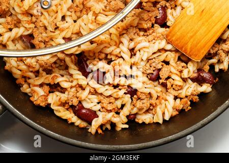 Closeup homemade pasta penne with chili con carne and beans. Top view. Stock Photo