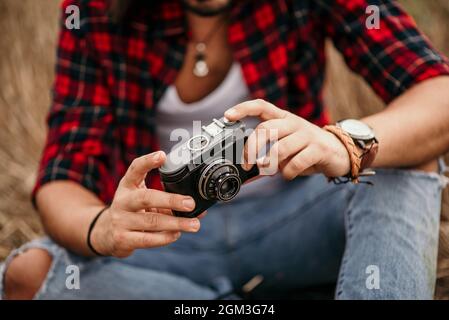 Young male photographer taking pictures of rural landscape using a vintage camera Stock Photo