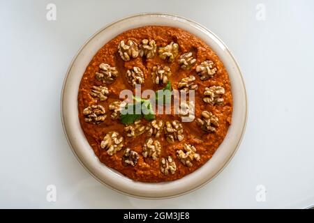 Red Muhammara close-up on table. horizontal top view , hot pepper dip originally from Syria, Lebanon. Stock Photo