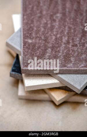 Samples of natural stone for kitchen countertops and floor tiles. Stone samples for countertops on gray background, copy space for design or text Stock Photo