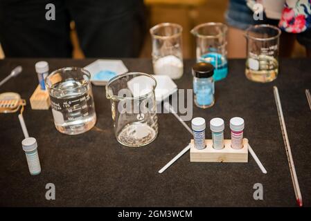 Science experiment materials including colorful liquid filled beakers and various vials and stirring mechanisms. Stock Photo