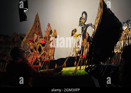 Javanese shadow puppet show or wayang kulit. Shadow puppets are usually staged from night to early morning and are free to watch by the public. Stock Photo