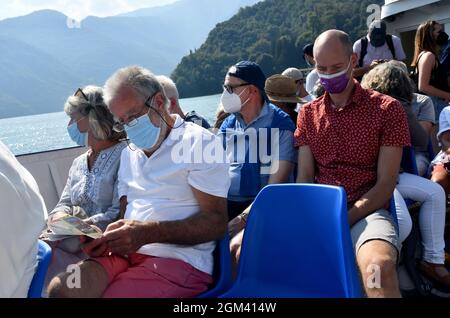 Tourists wearing Covid pandemic face masks on boat on Lake Como, Italy, Province of Como Stock Photo