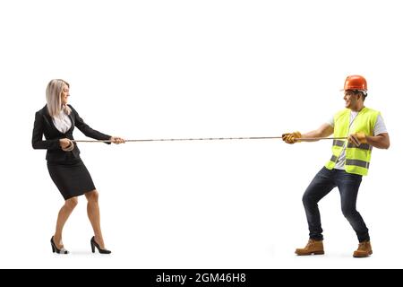 Full length profile shot of a construction worker and a businesswoman pulling a rope isolated on white background Stock Photo