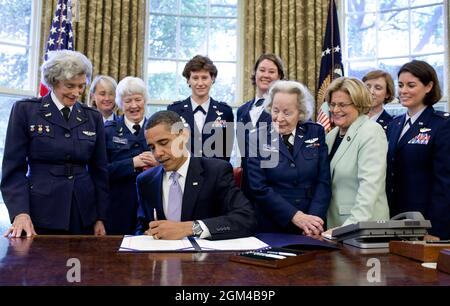 President Barack Obama signs S.614, a bill to award a Congressional Gold Medal to the Women Airforce Service Pilots, in the Oval Office Wednesday, July 1, 2009. Women Airforce Service Pilots (WASP) was established during World War II, and from 1942 to 1943, more than a thousand women joined, flying sixty million miles of non-combat military missions.  Of the women who received their wings as Women Airforce Service Pilots, approximately 300 are living today. (Official White House Photo by Pete Souza) This official White House photograph is being made available for publication by news organizati Stock Photo