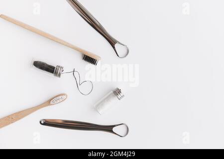 Dental hygiene set for couple. Bamboo toothbrush, dental floss and metal tongue scraper isolated on white, flat lay, top view Stock Photo