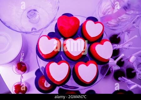 Candy bar. Sweet table with red and white mousse desserts in the form of heart for Valentine's Day. Delicious sweet buffet with cakes. Holiday buffet Stock Photo