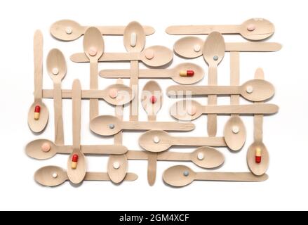 Medication servings. Pills ,capsules and tablets in neatly arranged wooden spoons Stock Photo
